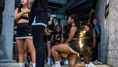 Three cheerleaders are seen kneeling in the tunnel by the field during the national anthem before Saturday's matchup between Kennesaw State and Gardner-Webb, Saturday, Oct. 21, 2017. (Special by Cory Hancock) Four cheerleaders kneeled during the anthem to continue the protests at KSU football games.