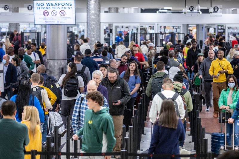 Travelers stand in line to go through the security checkpoint at Hartsfield-Jackson Atlanta International Airport during a busy Friday morning, October 28, 2022. (Steve Schaefer/steve.schaefer@ajc.com)