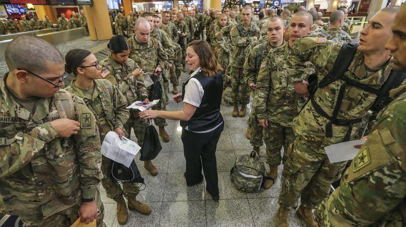 Delta Air Lines ticket agent Sheri Mullins (center) gave instructions on Tuesday to the 4000-plus Army soldiers from Ft. Benning heading out for holiday leave at Hartsfield-Jackson International Airport. The airport was getting back to normal on Tuesday, Dec. 19, 2017, two days after a massive power outage brought the world’s busiest airport to a standstill. JOHN SPINK/JSPINK@AJC.COM