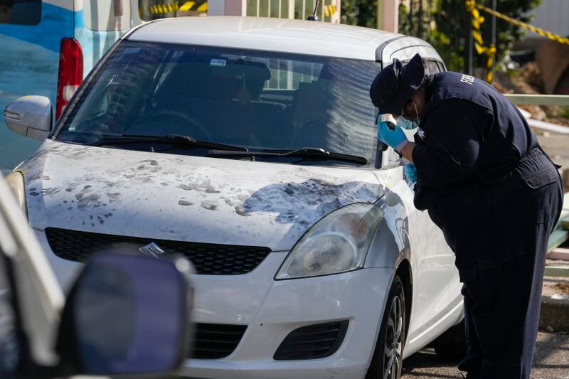 A police forensic officer inspects a car at the Christ the Good Shepherd Church in suburban Wakely in western Sydney, Australia, Tuesday, April 16, 2024. Australian police say a knife attack in Sydney that wounded a bishop and a priest during a church service as horrified worshippers watched online and in person, and sparked a riot was an act of terrorism. (AP Photo/Mark Baker)