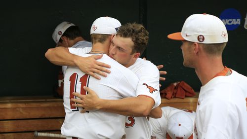 Texas right fielder Duke Ellis (11) and pitcher Bryce Elder hug in the dugout following the team's 6-1 loss to Florida in an NCAA College World Series baseball elimination game in Omaha, Neb., Tuesday, June 19, 2018. (AP Photo/Nati Harnik)
