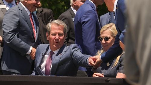 Gov. Brian Kemp hands off a pen after signing Senate Bill 233, known as the Georgia Promise Scholarship Act, at Liberty Plaza on Tuesday, April 23, 2024. (Natrice Miller/ AJC)