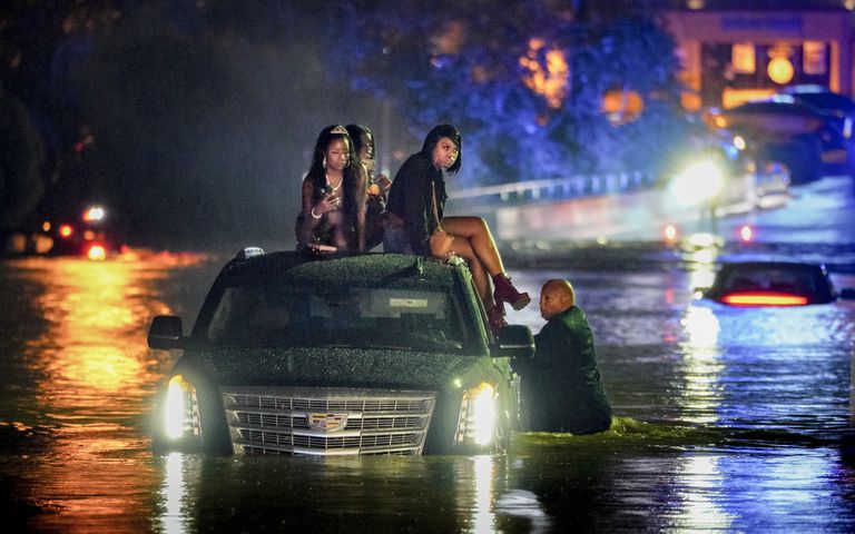 A Sept. 7 storm deluged parts of Cobb, Fulton, Gwinnett and Forsyth counties with several inches of rainfall over 24 hours. In this photos, a limousine driver stands in floodwaters as his passengers take shelter on the roof. Multiple vehicles stalled on Delk road amid rising flood waters. Ben Hendren for the AJC