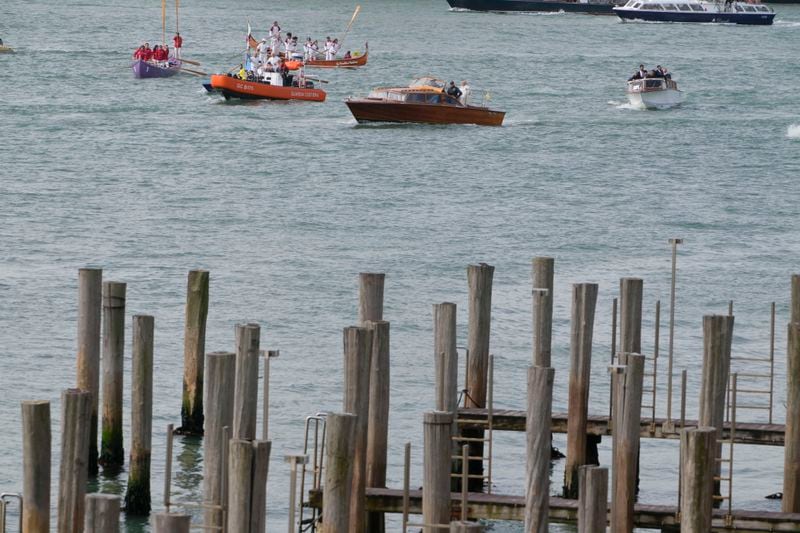 Pope Francis, aboard of a speedboat foreground, is greeted by Gondoliers upon his arrival in Venice, Italy, Sunday, April 28, 2024. The Pontiff arrived for his first-ever visit to the lagoon town including the Vatican pavilion at the 60th Biennal of Arts. (AP Photo/Alessandra Tarantino)