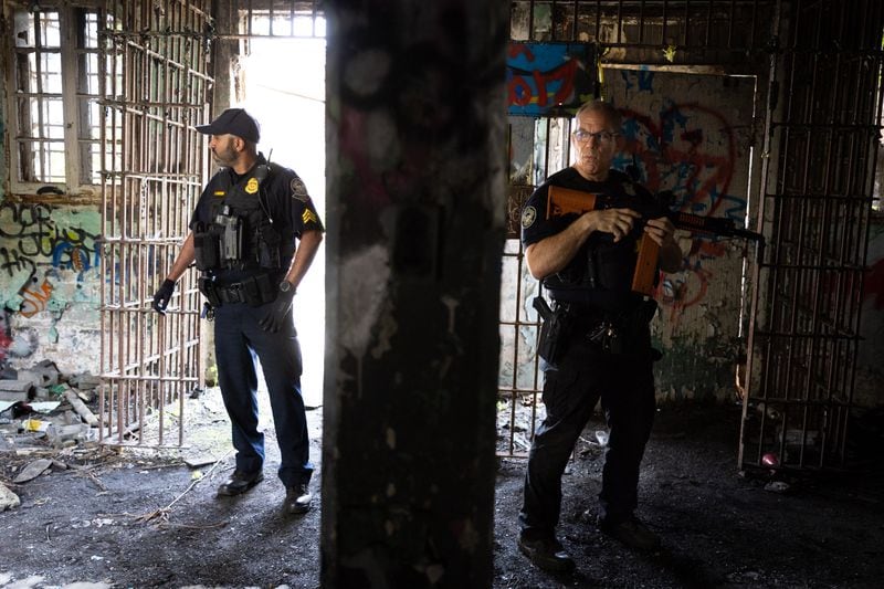 Officers stand in an Old Prison Farm building during an Atlanta Police Department and Atlanta Fire Rescue media tour of the Atlanta Public Safety Training Center Site in Atlanta on Friday, May 26, 2023. (Arvin Temkar / arvin.temkar@ajc.com)