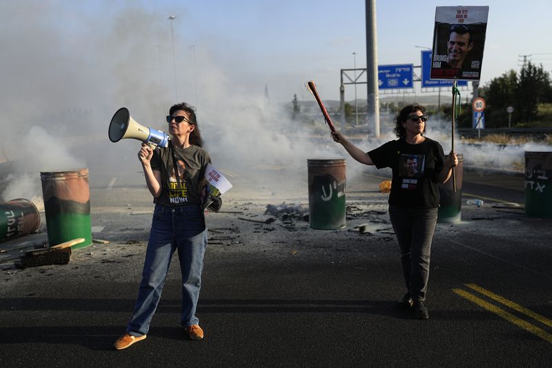 Relatives of hostages held in the Gaza Strip block Highway 1, the main route linking Tel Aviv and Jerusalem, to call for a deal to release all hostages, Friday, April 19, 2024. (AP Photo/Ohad Zwigenberg)