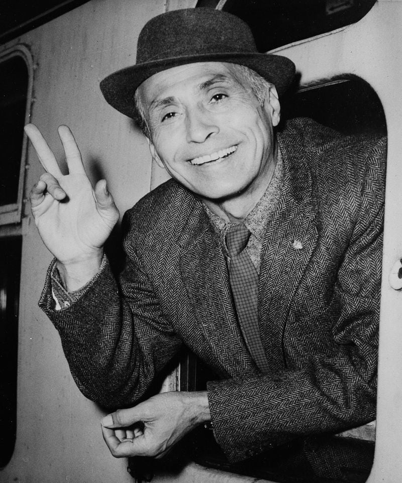 Mexican-American choreographer and dancer Jose Limon waves hello from a train window as he arrives at Waterloo Station in London, England, on Aug. 27, 1957.  (AP Photo)