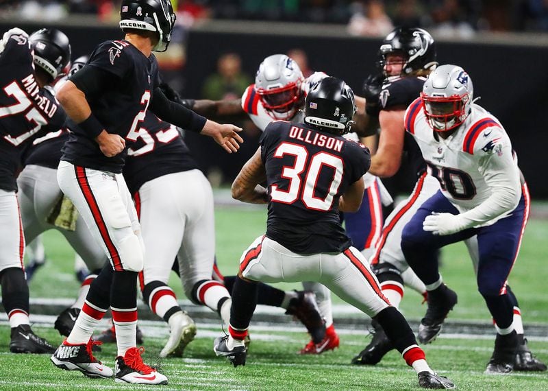 Falcons quarterback Matt Ryan hands off to running back Qadree Ollison who is stopped at the line of scrimmage by Patriots defenders during the second half in a NFL football game on Thursday, Nov. 18, 2021, in Atlanta.    “Curtis Compton / Curtis.Compton@ajc.com”