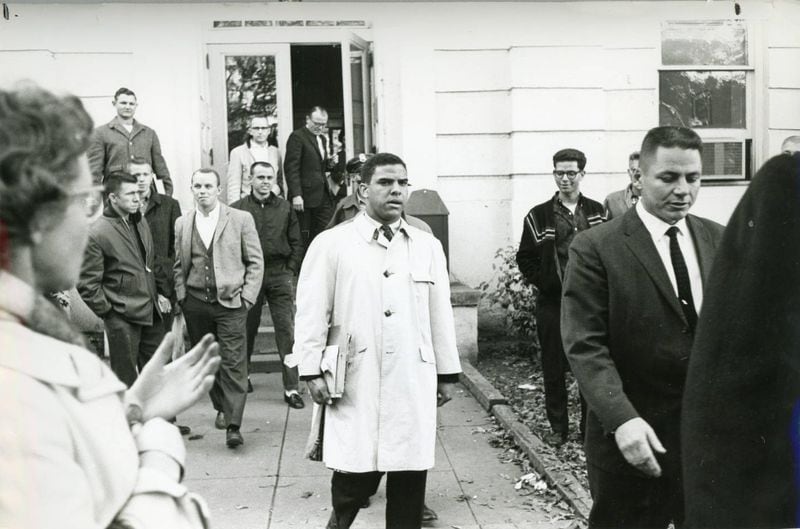 Hamilton Holmes, one of the first two African-American students to integrate the University of Georgia, leaving a campus building in Athens, Georgia Jan. 111961. White male students are shown in the background. (Bill You ng / AJC Archive at GSU Library AJCP426-125b)