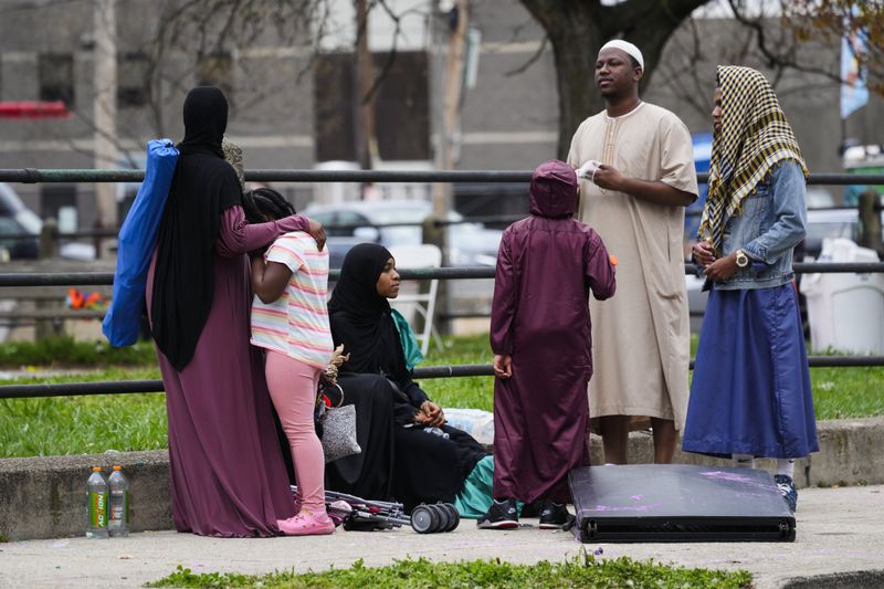 People gather in the aftermath of a shooting at an Eid al-Fitr event in Philadelphia, Wednesday, April 10, 2024. (AP Photo/Matt Rourke)