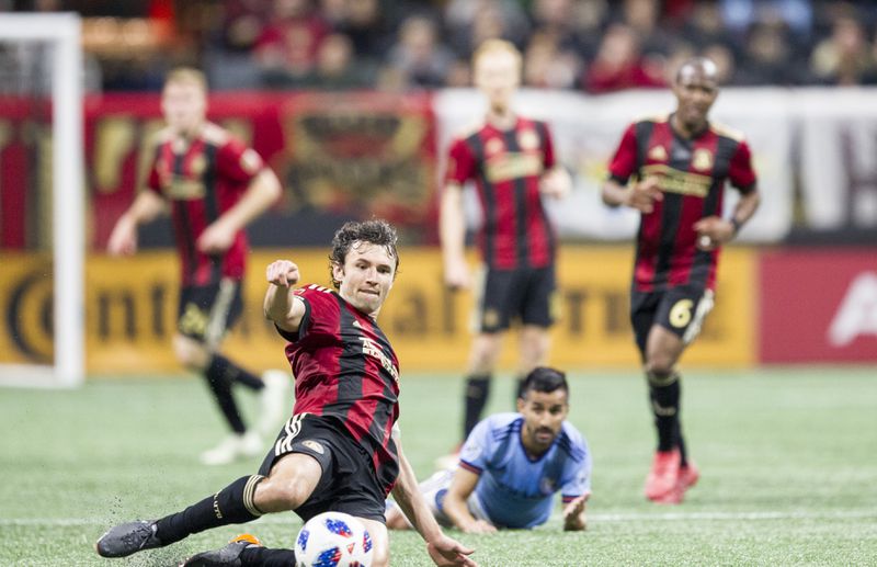 Atlanta United defender Michael Parkhurst (3) slides across the field to kick the ball during the match between NYC FC and Atlanta United at Mercedes-Benz Stadium in Atlanta, Georgia, on Sunday, April 15, 2018. (REANN HUBER/REANN.HUBER@AJC.COM)