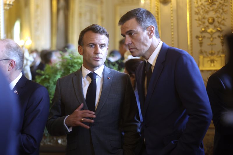 French President Emmanuel Macron, left, speaks with Spain's Prime Minister Pedro Sanchez during a reception at the Royal Palace prior to an EU summit in Brussels, Wednesday, April 17, 2024. (Olivier Hoslet, Pool Photo via AP)