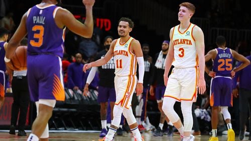 Hawks guard Trae Young smiles at Suns guard Chris Paul, with Kevin Huerter looking on, in the final minute of a 124-115 victory over the Suns. (Curtis Compton / Curtis.Compton@ajc.com)
