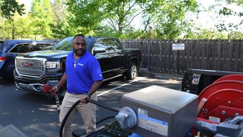 Brian Glanton, a field technician and supervisor for Yoshi, fills up a gas tank in an Atlanta area parking lot. Yoshi, a San Francisco venture backed by Exxon and GM, is doubling down on its operations in metro Atlanta, where it delivers fuel directly to customers’ vehicles at work or home. (Rebecca Breyer)