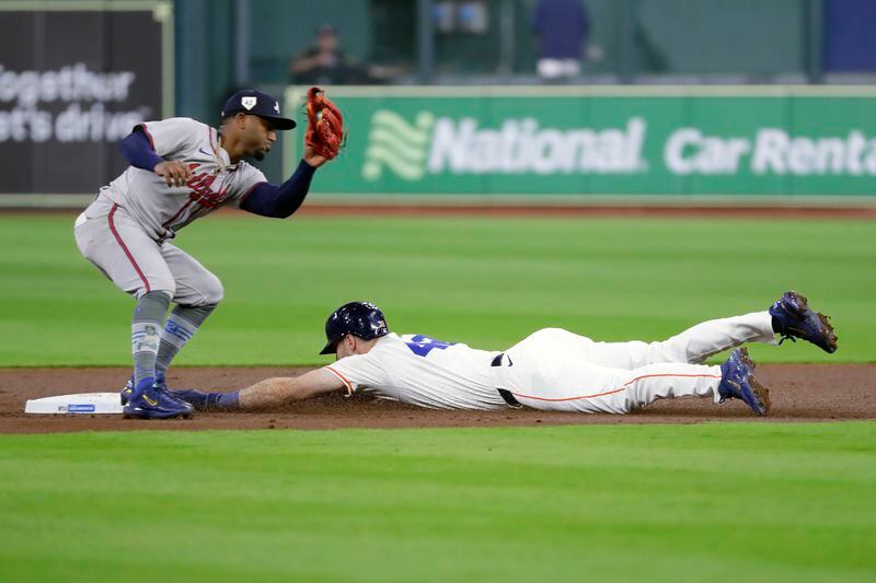 Houston Astros' Kyle Tucker, right, safely steals second base as Atlanta Braves second baseman Ozzie Albies is last with the tag during the first inning of a baseball game, Monday, April 15, 2024, in Houston. (AP Photo/Michael Wyke)