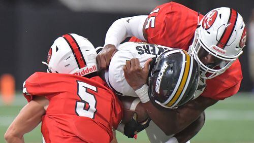 Colquitt County wide receiver Lemeke Brockington (17) is tackled by North Gwinnett's Jack Mcgill (5) and Jared Ivey (15) in the second half of  the Corky Kell Classic Saturday, Aug. 24, 2019, at Mercedes-Benz Stadium.