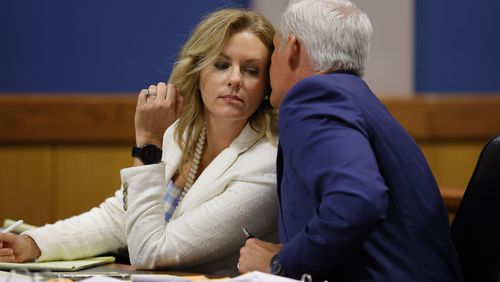 Defense attorney Ashleigh Merchant speaks to her husband and co-counsel John Merchant during a hearing on the Georgia election interference case, Friday, March, 1, 2024, in Atlanta. (AP Photo/Alex Slitz, Pool)