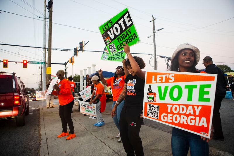 Volunteers encouraged citizens to vote on Nov. 8, 2022, across the street from the Metropolitan Library in Atlanta. Voters will return to the polls on Dec. 6 for the U.S. Senate runoff election. (Christina Matacotta for the Atlanta Journal-Constitution)