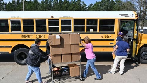 Gwinnett County School Bus drivers and staff load school buses with foods to deliver free meals to students in March 20, 2020.  (Hyosub Shin / Hyosub.Shin@ajc.com)