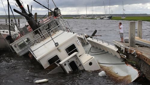 Dozens of boats are blown into the marsh and a shrimp boat sits on the bottom as local resident Michael Whitemore, 36, checks to see whether a friend’s boat survived at Langs Marina after Hurricane Irma hit St. Marys on Monday, Sept. 11, 2017.
