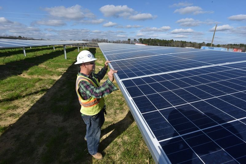 A worker with Solar Panel Solutions inspects solar panels in Bronwood, Ga. Solar energy accounts for only a small portion of Georgia’s electric power. But the sun is generating a growing segment of the state’s energy picture. HYOSUB SHIN / HSHIN@AJC.COM
