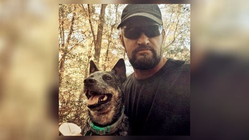 Christopher Burkett, shown with his dog Kiah, was killed in November 2021 while trying to help two women get out of a train's path. He was 47.