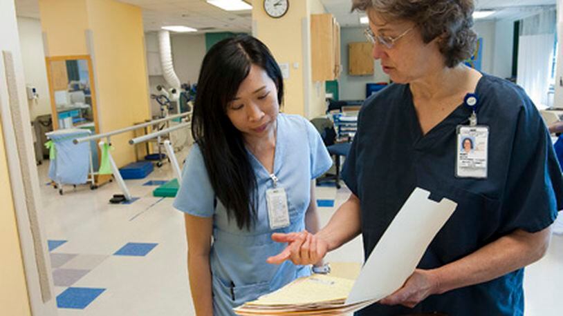 Occupational therapist Linh Do (left) confers with Mary White, senior physical therapist, about a patient’s chart at the Marcus Stroke & Neuroscience Center in Atlanta. Learn about strokes on May 16 at Fayette Senior Services, The Life Enrichment Center, 4 Center Drive, Fayetteville during this free program. (Courtesy of Barry Williams)