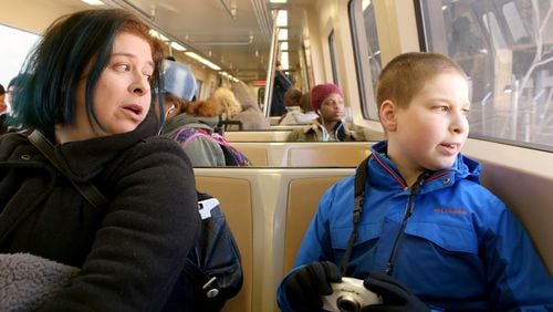 Gabriel and his mother Alison sit aboard a MARTA train. (HENRY TAYLOR / HENRY.TAYLOR@AJC.COM)