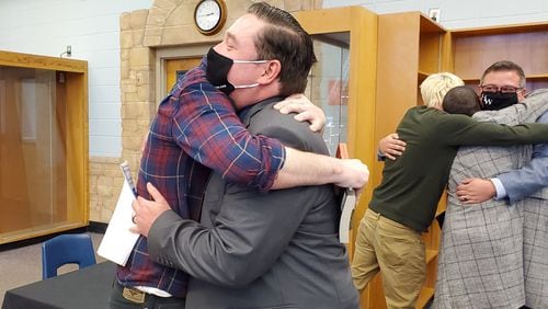 Spencer Jordan, a Campbell High School drama teacher, hugs a former student after a panel overturned the Cobb school district's decision not to renew his contract. Credit: Kristal Dixon/The Atlanta Journal-Constitution.