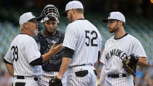 Jimmy Nelson #52 of the Milwaukee Brewers talks with pitching coach Rick Kranitz #39, Martin Maldonado #12, and Jonathan Lucroy #20 after a rough first inning against the Pittsburgh Pirates at Miller Park on July 18, 2015 in Milwaukee, Wisconsin.  (Photo by Tom Lynn/Getty Images)