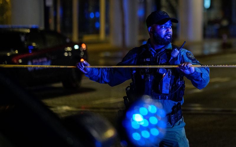 An Atlanta police officer secures the scene after a shooting at the 17th Street bridge near Atlantic Station left one person dead and several injured Saturday night.