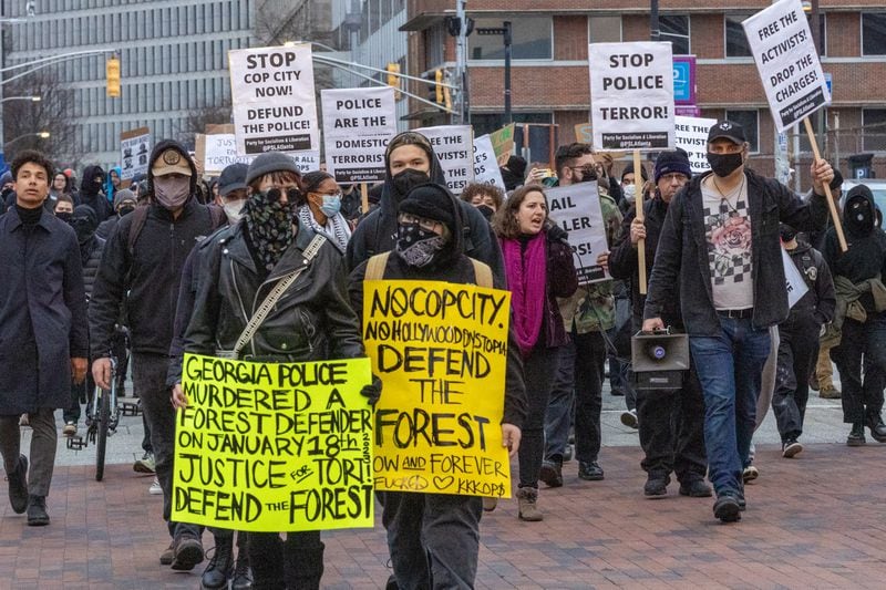 Forest Defender protesters march in the streets near Underground Atlanta on Saturday. The Atlanta Police Department said several people were arrested after a police car was set afire.  (Steve Schaefer/steve.schaefer@ajc.com)