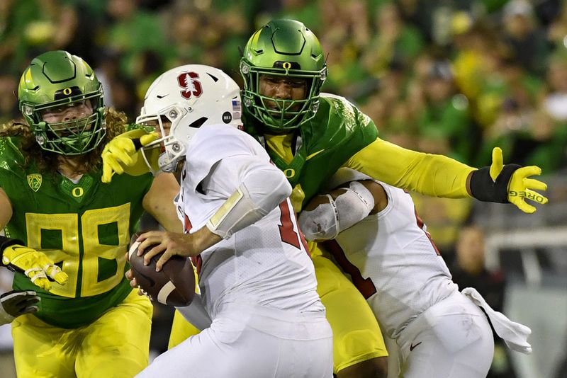 FILE - Oregon defensive end Brandon Dorlus (3) sacks Stanford quarterback Tanner McKee (18) as defensive lineman Casey Rogers (98) comes in on the play during the second half of an NCAA college football game Saturday, Oct. 1, 2022, in Eugene, Ore. Oregon opens their season at home against Portland State on Sept. 2. (AP Photo/Andy Nelson, File)