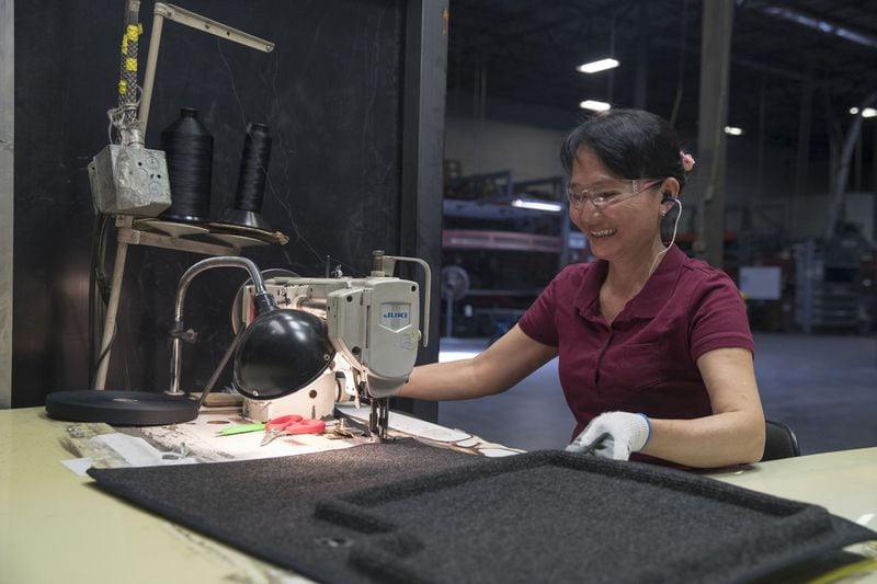 Lund employee Tuong Tran assembles a car mat at the company’s Lawrenceville factory, which employs more than 500 people. ALYSSA POINTER/ALYSSA.POINTER@AJC.COM