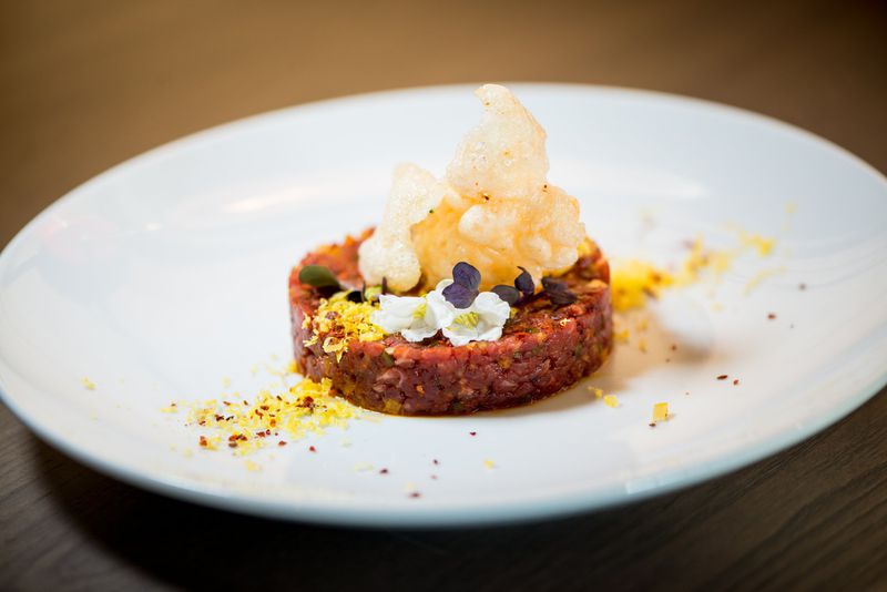 Noona Beef Tartare with cured egg yolk, preserved yuzu, Korean chile, shallot, smoked salt, and rice puff. CONTRIBUTED BY MIA YAKEL