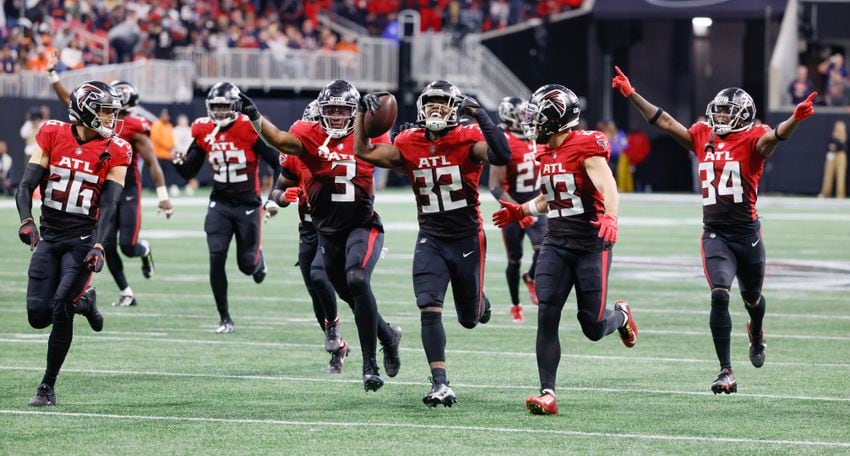 Falcons safety Jaylinn Hawkins (32) celebrates with teammates after he intercepted Chicago's Justin Fields during the fourth quarter Sunday. The host Falcons won 27-24. (Bob Andres / for The Atlanta Journal-Constitution)