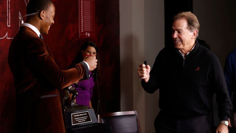 In a photo provided by the Heisman Trophy Trust, Alabama wide receiver DeVonta Smith, left, bumps fists with Alabama coach Nick Saban after Smith won the Heisman Trophy, Tuesday, Jan. 5, 2021, in Tuscaloosa, Ala. (Kent Gidley/Heisman Trophy Trust via AP)