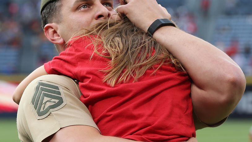 051116 ATLANTA: U.S. Marine Corps SSG Clayton Walker is moved to tears as he is reunited with his daughter Cassidy, 10, Langston Elementary School, Perry, GA, after his fifth tour of duty just before the first pitch in the Braves and Phillies baseball game at Turner Field on Wednesday, May 11, 2016, in Atlanta. Curtis Compton / ccompton@ajc.com
