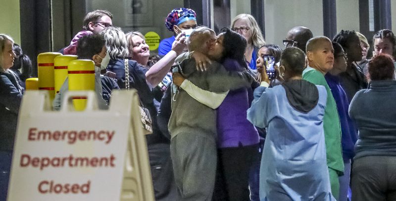 Medical workers embraced one another after closing Atlanta Medical Center’s emergency room on Friday, Oct 14, 2022. (John Spink / John.Spink@ajc.com) 

