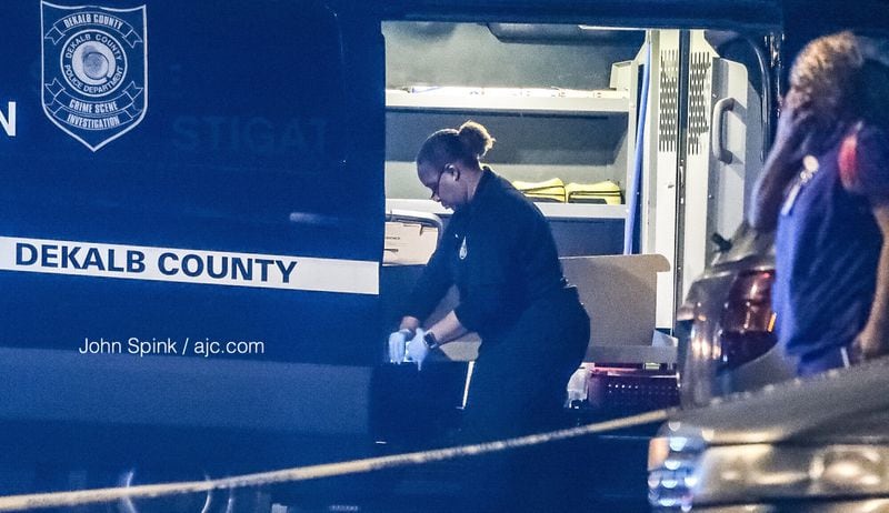 DeKalb police investigators work the scene of a triple shooting at an apartment complex off Flat Shoals Road Thursday morning. One man is dead and two others are in “extremely grave condition,” according to police. JOHN SPINK / JSPINK@AJC.COM