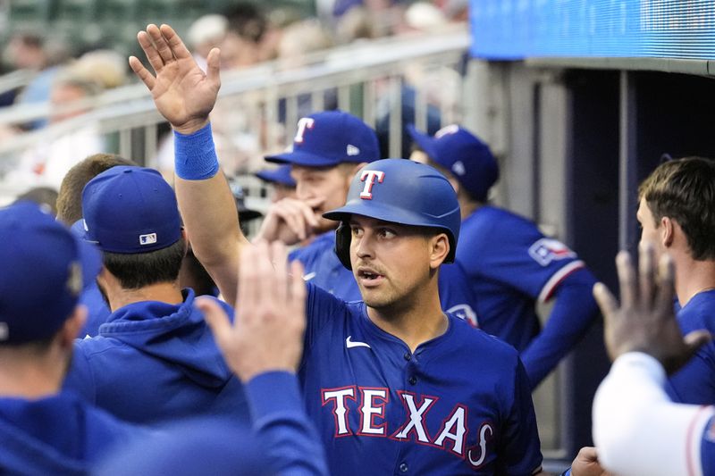 Texas Rangers' Nathaniel Lowe reacts in the dugout after scoring on a Andrew Knizner ground ball in the second inning of a baseball game against the Atlanta Braves Saturday, April 20, 2024, in Atlanta. (AP Photo/John Bazemore)