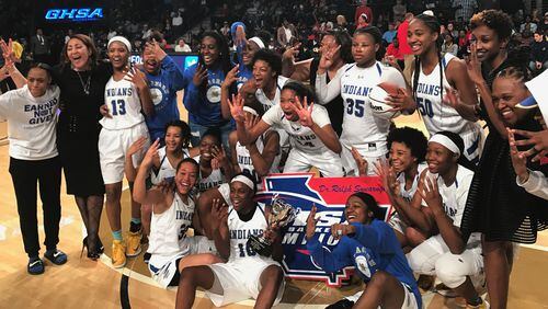 The McEachern Lady Indians pose with the AAAAAAA title trophy after beating Norcross for their fourth consecutive championship.