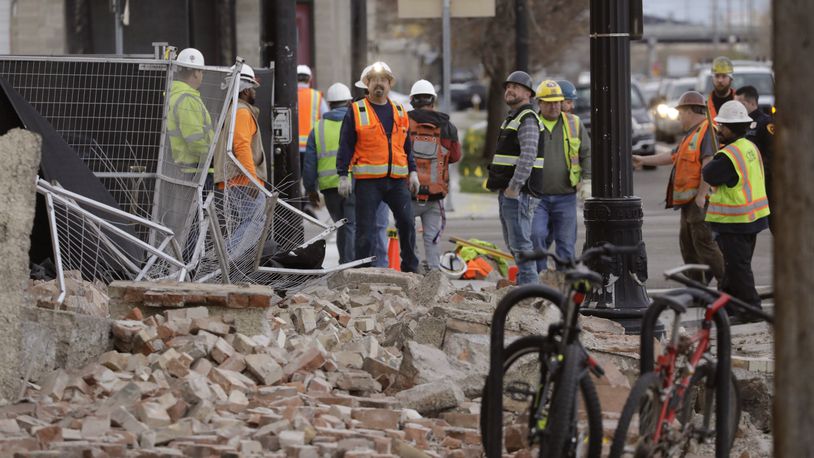 Construction workers looks at the rubble from a building after an earthquake Wednesday in Salt Lake City.