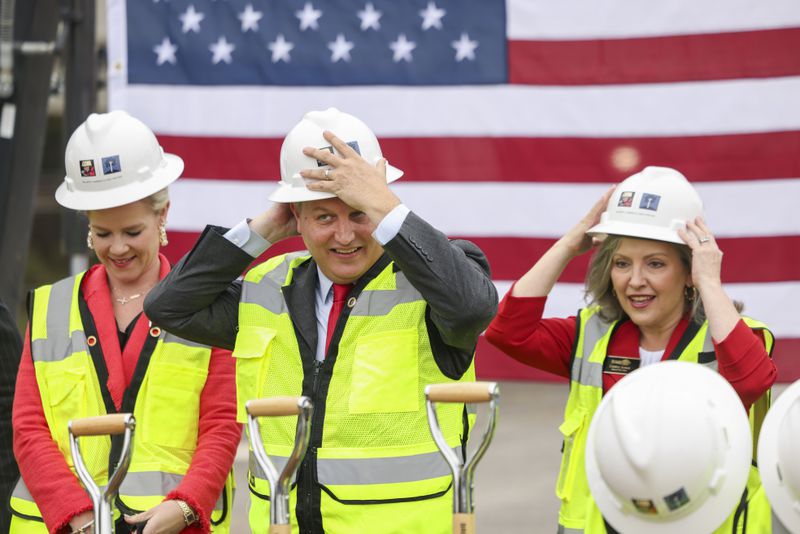 Brookhaven Mayor John Ernst, center, and City Councilwomen Madeleine Simmons, left, and Linley Jones put on hard hats before performing a groundbreaking ceremony for Brookhaven’s $78 million City Hall at the Brookhaven MARTA Station parking lot, Wednesday, October 11, 2023, in Atlanta. (Jason Getz / Jason.Getz@ajc.com)