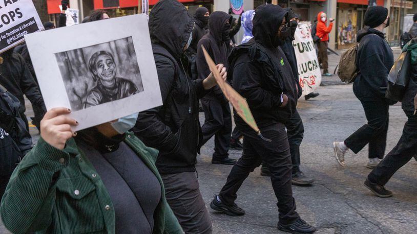 Forest Defender protesters march in the streets near Underground Atlanta Saturday, Jan. 21, 2023. Atlanta Police Department said several people were arrested after a Police car was set afire. 