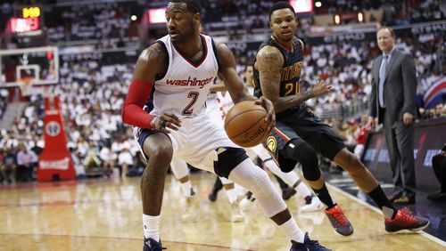 Washington Wizards guard John Wall (2) dribbles the ball while Atlanta Hawks forward Kent Bazemore (24) defends during the first half in Game 1 of a first-round NBA basketball playoff series, in Washington, Sunday, April 16, 2017. The Wizards won 114-107. (AP Photo/Manuel Balce Ceneta)