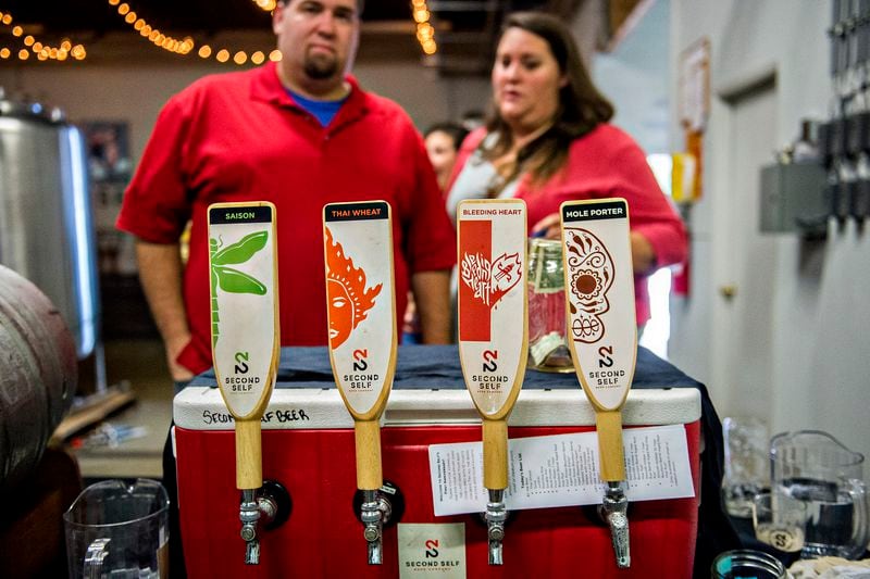 October 3, 2015 Atlanta - Austin Little (left) and Leslie Klein decide what beer to try during the Second Self Beer Company's one year anniversary celebration in Atlanta on Saturday, October 3, 2015. The brewery had 16 different beers to sample during the celebration. JONATHAN PHILLIPS / SPECIAL