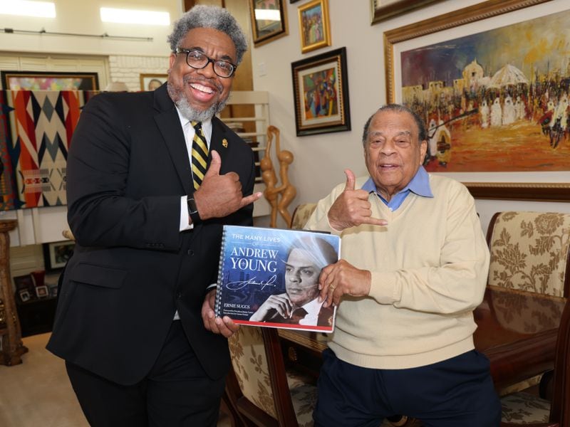 Author and Atlanta Journal-Constitution reporter Ernie Suggs and Ambassador Andrew Young flash the Alpha Phi Alpha Fraternity sign while holding a copy of the new book, "The Many Lives of Andrew Young." (Tyson A. Horne / tyson.horne@ajc.com)