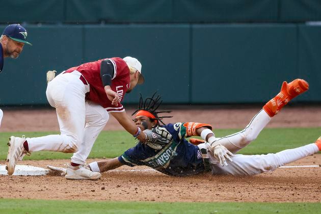 Grayson’s Landon Arroyos (2) slides safely ahead of the tag from Lowndes third baseman Ashton Bohler (5) during the tenth inning in game one of the Class 7A GHSA baseball finals at Coolray Field, Friday, May 17, 2024, in Lawrenceville, Ga. Lowndes won 4-3. (Jason Getz / AJC)
