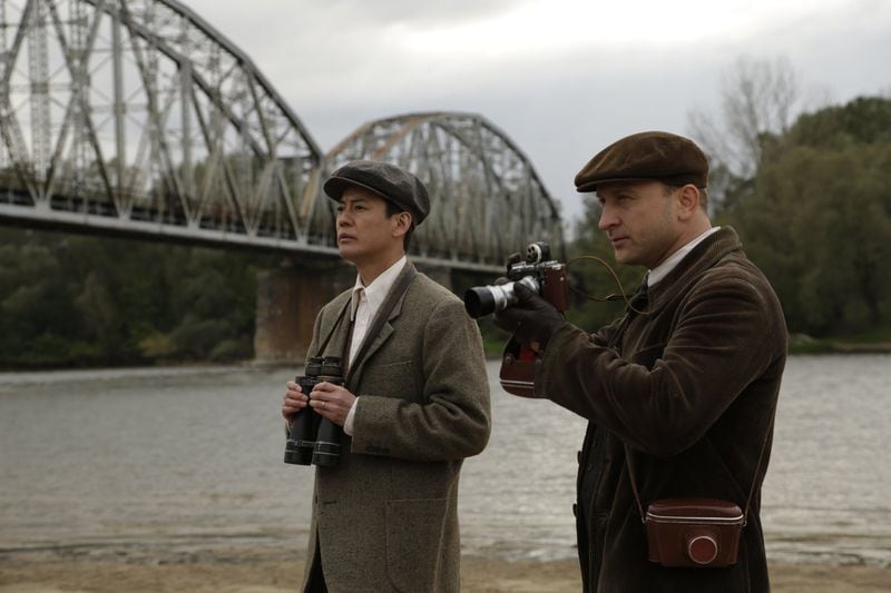 Chiune Sugihara (Toshiaki Karasawa, left) and his right-hand man Pesch (Borys Szyc) watch refugees crossing a bridge in a bid to escape the arrival of the Russians, followed by the Nazis, in the movie “Persona Non Grata.” CONTRIBUTED BY ATLANTA JEWISH FILM FESTIVAL
